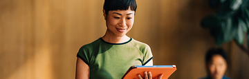 Woman holding a tablet.