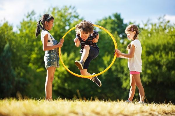 Three children playing and laughing in a field