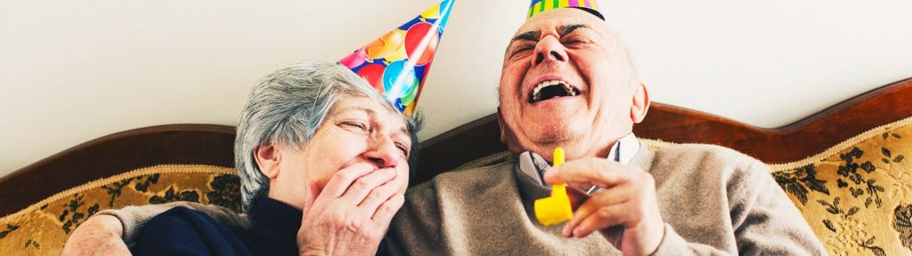 A joyful elderly couple sit together, symbolizing the celebration of their new chapter in retirement