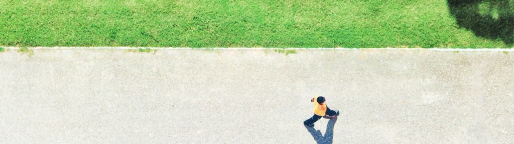 Aerial view of an individual walking on a paved path, symbolizing the journey of retirement and the need for emergency savings.