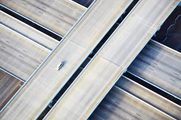 Aerial view of a single car driving along a highway