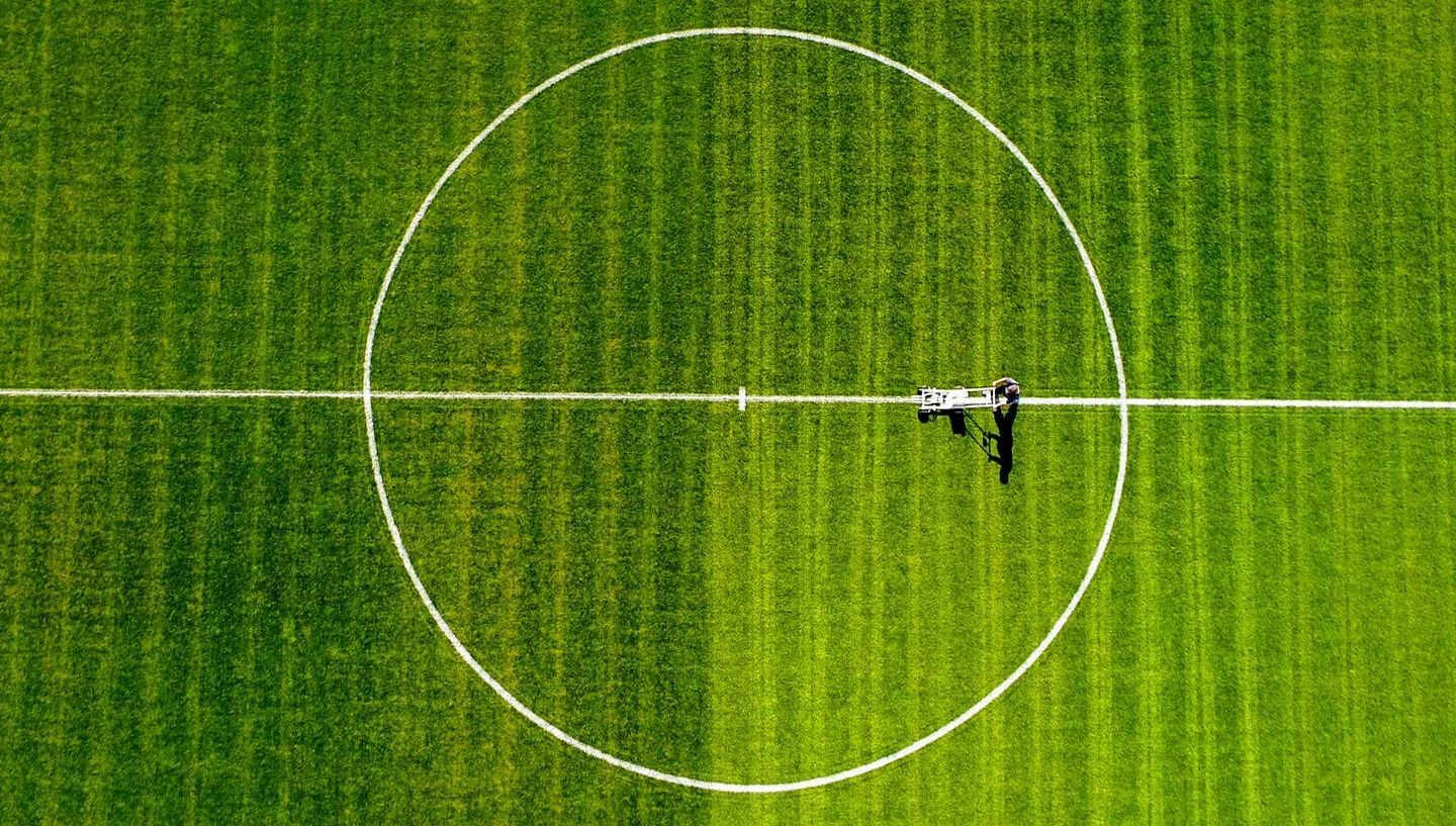 Aerial view of a soccer field featuring a center white line marking the playing area.