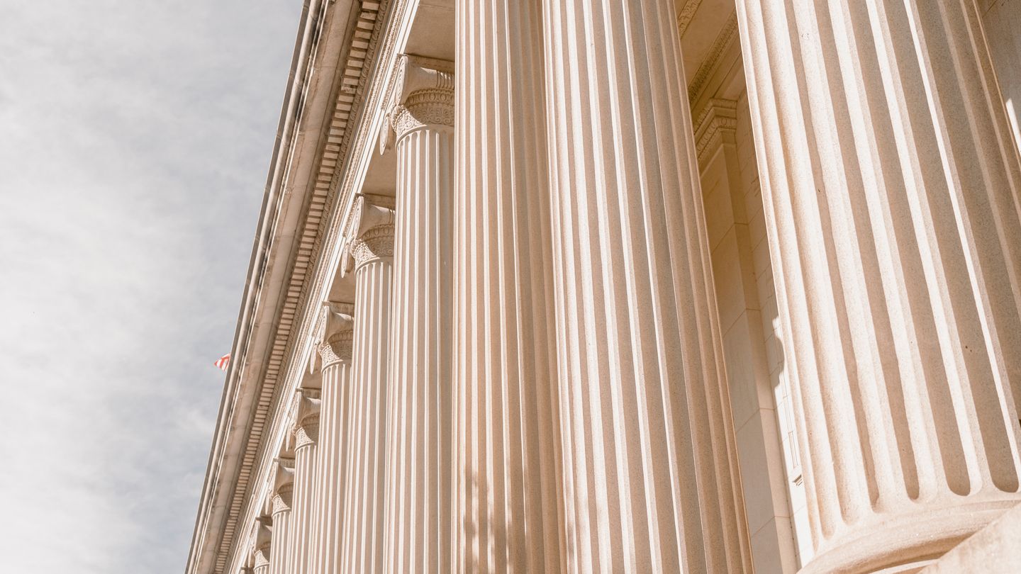 Close-up of a classical building exterior with large fluted columns supporting an entablature, suggesting a government or museum structure.